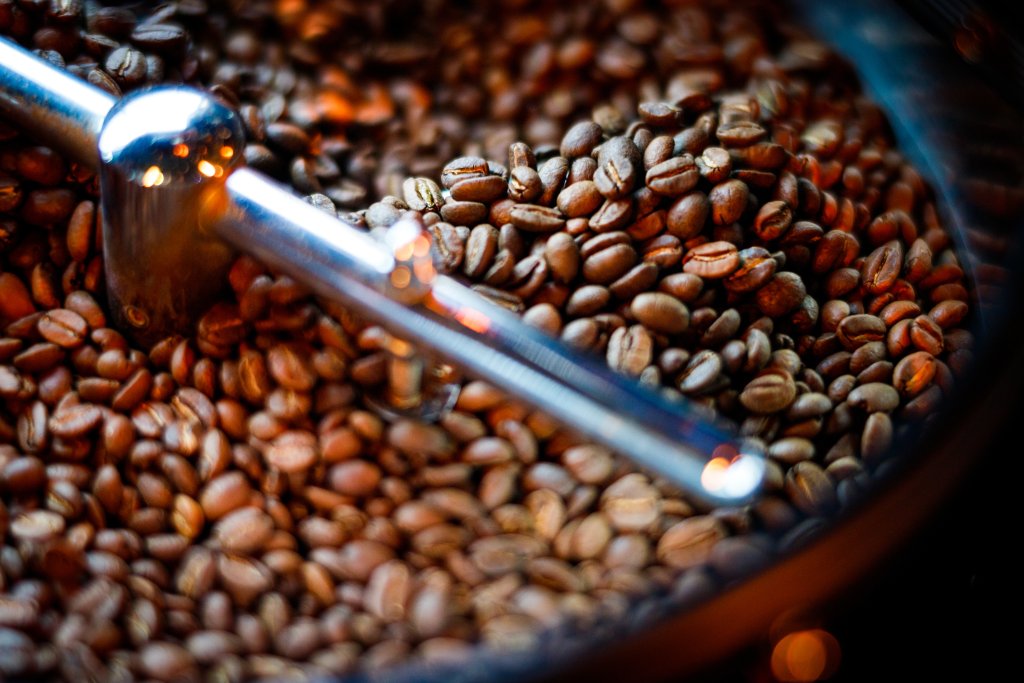 Coffee beans are limited in the coffee machine. Blending grains with artificial light in reds, browns and blacks.