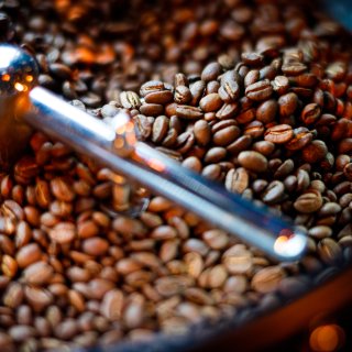 Coffee beans are limited in the coffee machine. Blending grains with artificial light in reds, browns and blacks.