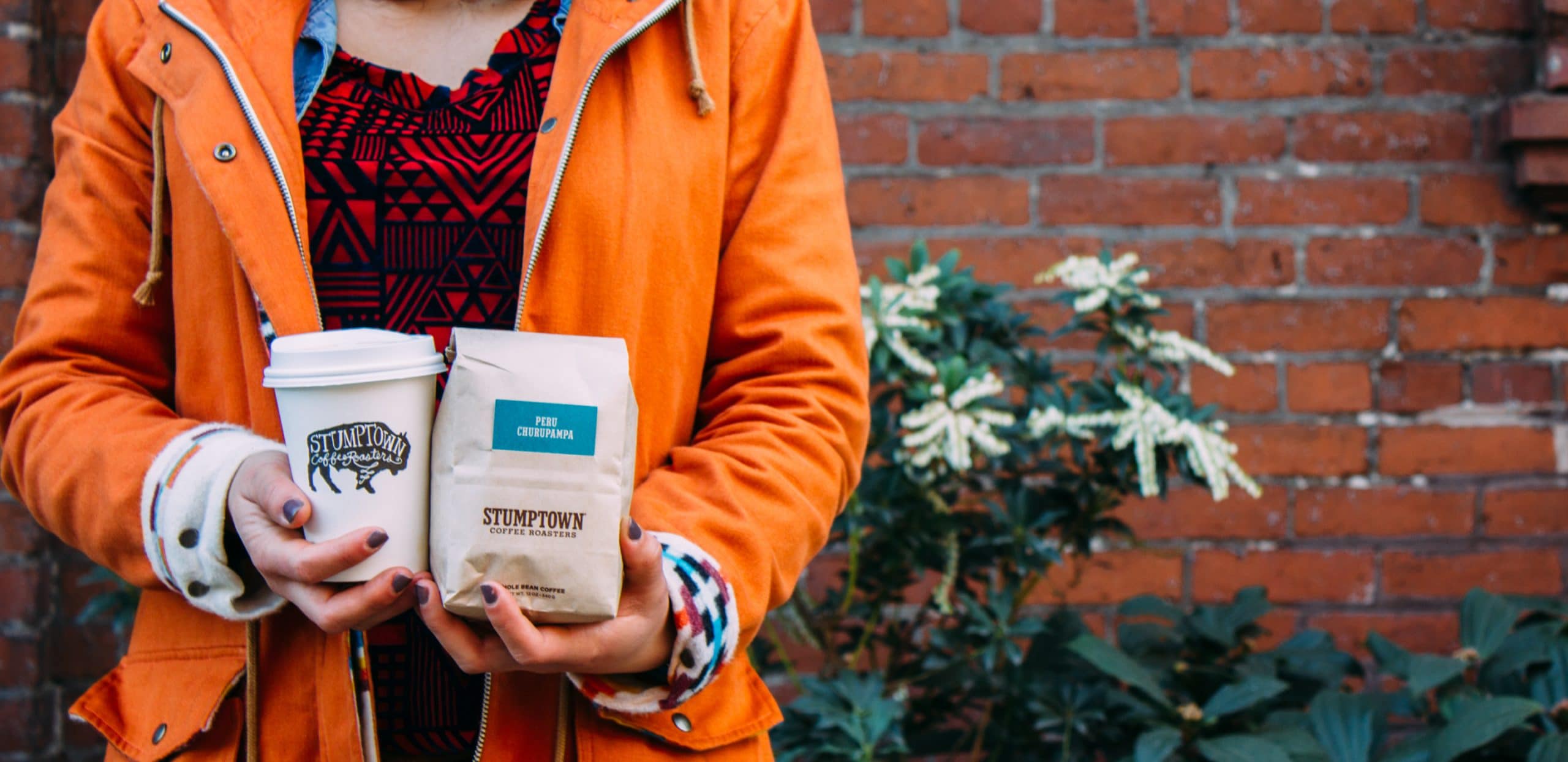 Holding a Stumptown Coffee and bag.