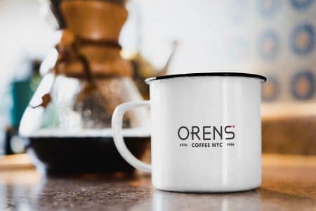 orens logo on a mug with coffee brewing