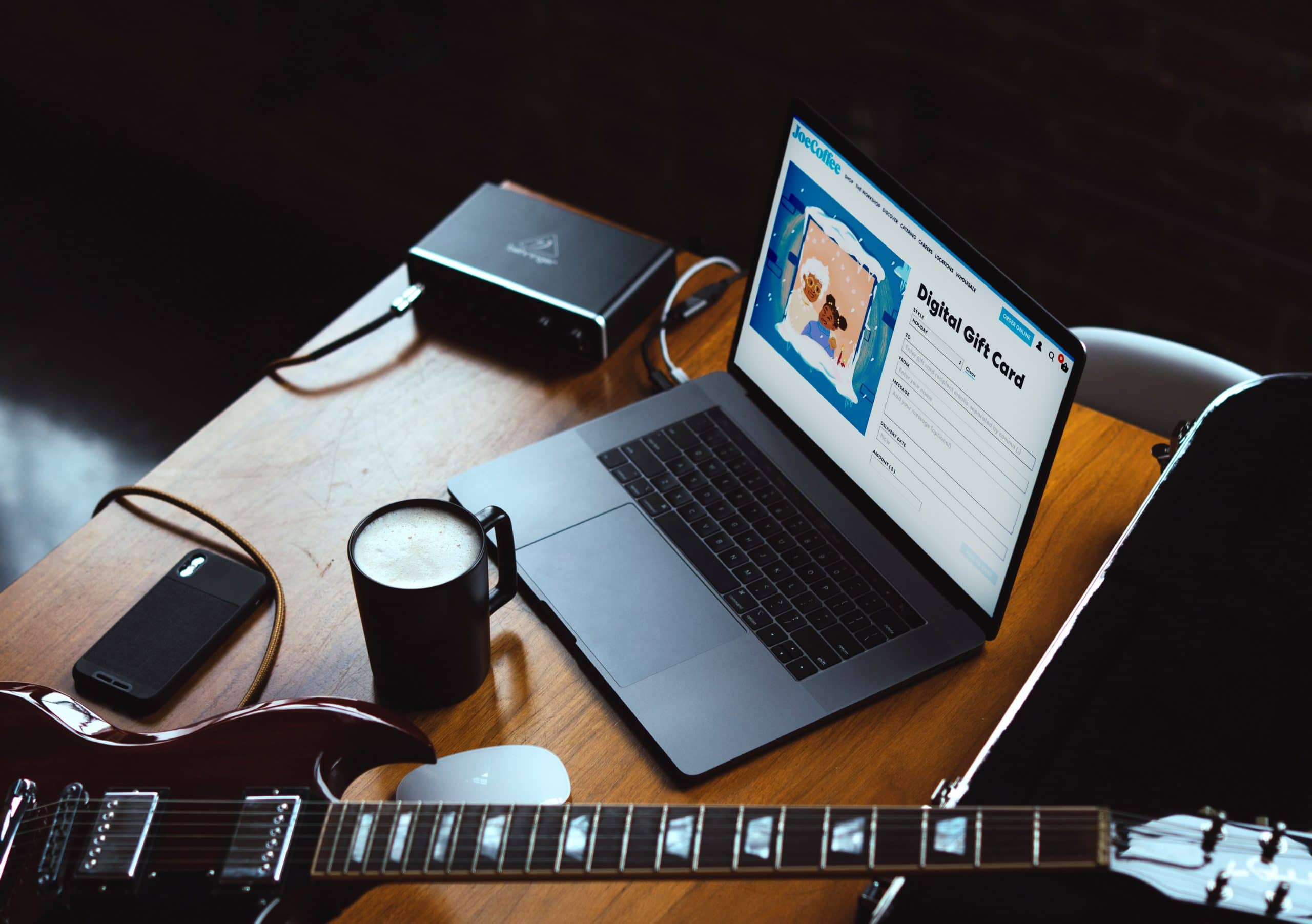 Digital gift card page on a laptop, surrounded by coffee and musical instruments